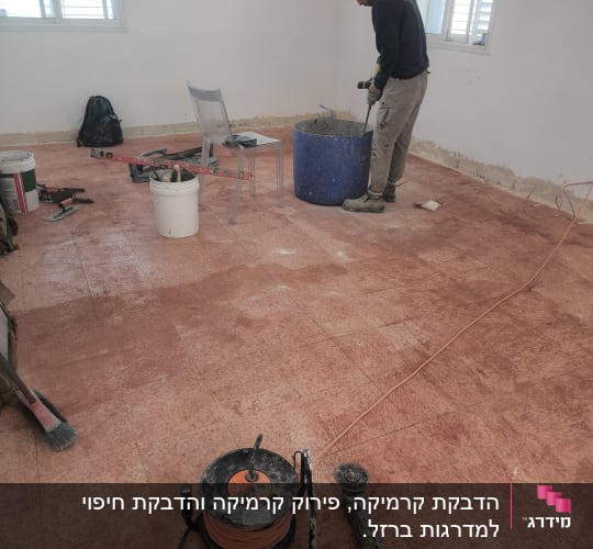 אדם מערבב חומר בדלי כחול עם מקדחה